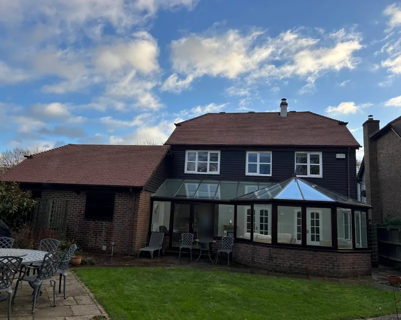 Back of the house with the main roof cleaned, conservatory and patio in front